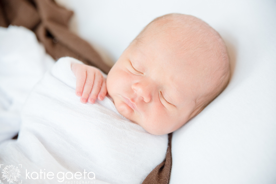 Newborn sleeping with hand out of wrap